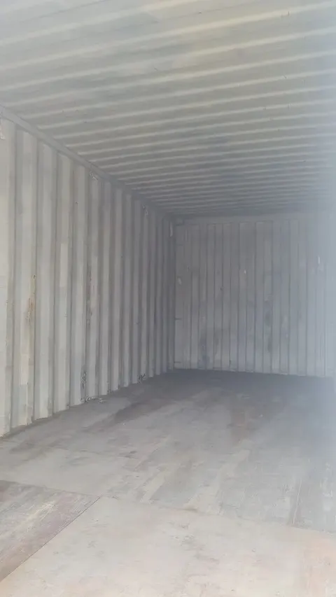 Interior vazio de container marítimo de 20 pés, com paredes corrugadas e piso de madeira